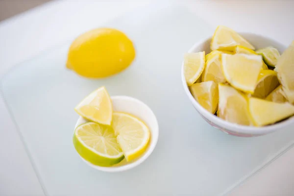 Сочный лимон и миски лаймов на столе — стоковое фото