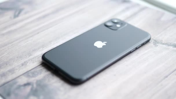 나무 탁자 위에 검은 색으로 나타나 있는 아이폰 11 — 비디오