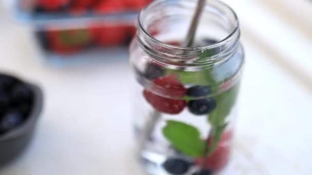 Maliny, jagody i napoje miętowe wewnątrz słoika — Wideo stockowe