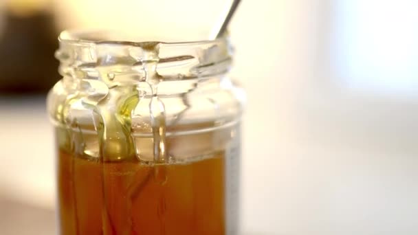 Ніж наливає мед на край банки — стокове відео