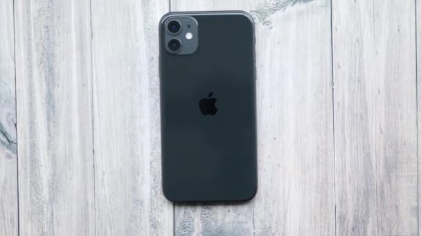 Czarny iPhone 11 na drewnianym stole z góry — Wideo stockowe