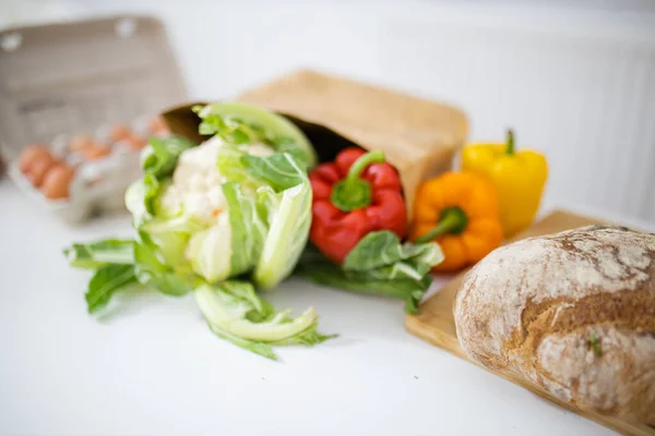 Cauliflower and bell peppers on white table next to bread — Stock Photo, Image