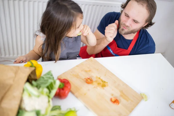 Feliz niña y su padre comiendo rodajas de limón — Foto de Stock