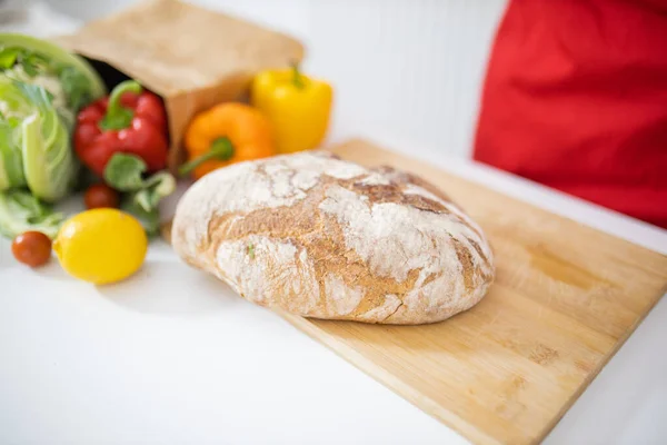 Tahtadaki ekmek, sebze paketinin yanında.