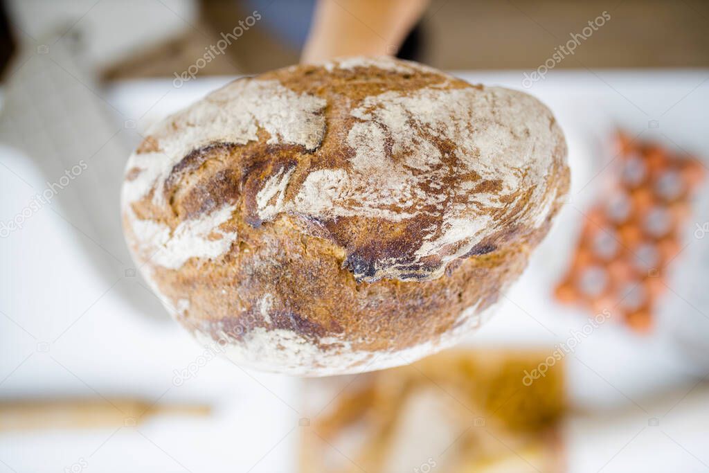 Female hand holding bread above ingredients on a table