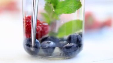 Ahududu, yabanmersini ve nane likörü bir kavanozun içinde.