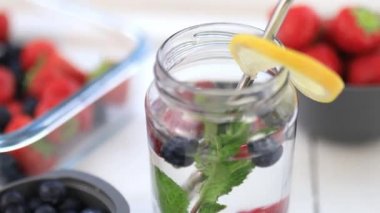 Bardağın kenarında limon dilimi ve içinde böğürtlen