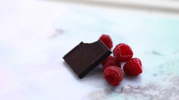 Bitten csokoládé és málna egy színes placemat — Stock videók