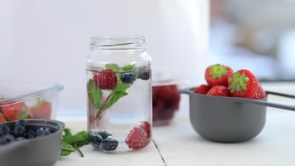 Bleuets, framboises et boisson à la menthe dans un pot — Video