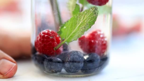 Paille brassant lentement framboises, bleuets et boisson à la menthe — Video