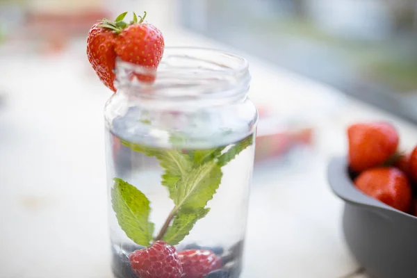 Aardbei aan de rand van een munt en bessen drinken — Stockfoto