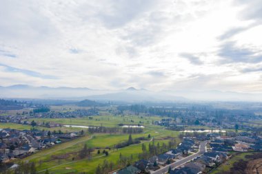 Arka planda dağları olan ağaçlarla çevrili huzurlu bir kasaba.