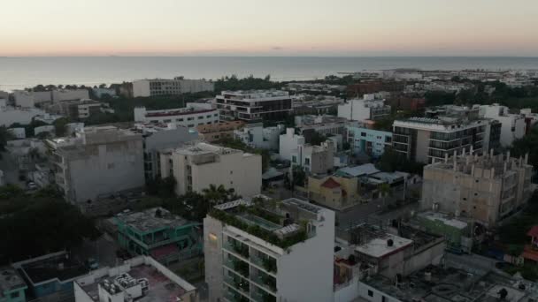 4k antenn cirkel runt ett tak klubb i en karibisk stad vid soluppgången — Stockvideo