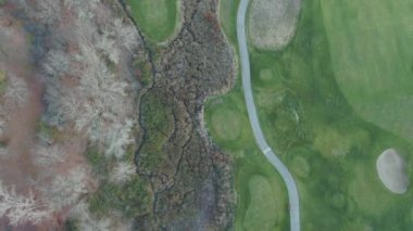 Golf sahasından Yukarı Bakış Bir Kasaba ve Dağların Manzarası