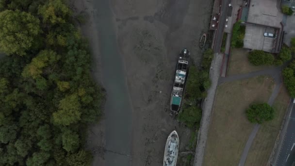 Vista aérea de 4k volando sobre un lecho de río de Londres cerca de Chiswick con barcos estacionados — Vídeos de Stock