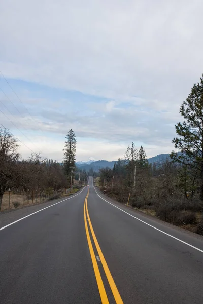 Empty road in the middle of dry nature with mountains in the distance — Stock Photo, Image