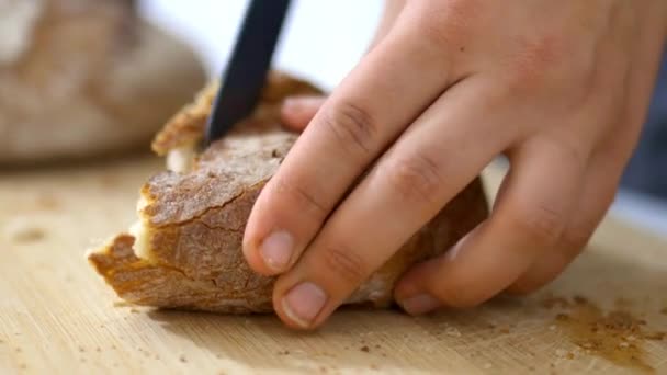 Mains féminines tranchant du pain sur une planche à découper — Video