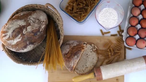 Bread, spaghetti, and eggs on a white table — Stock Video