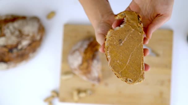 パンのスライスにピーナッツバターを広げる女性の手 — ストック動画