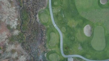 4k Hava Görüntüsü Golf Sahasının Üzerinde ve yanındaki Kahverengi Ağaçlar Grubu