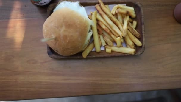 Shot van een Burger Fries naast een bierflesje in een restaurant in Bacalar Mexico — Stockvideo