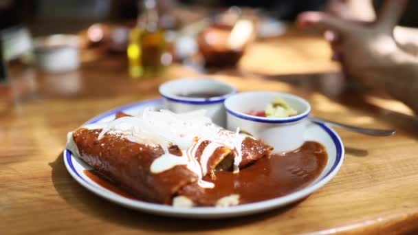 Tiros girando em torno de pratos mexicanos Enchiladas na mesa de um restaurante — Vídeo de Stock