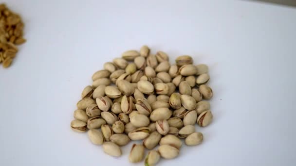 Grupos de frutos secos y semillas sobre una mesa blanca — Vídeo de stock