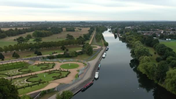Vista volando sobre el río detrás del palacio de Hampton Court con la ciudad en el fondo — Vídeos de Stock