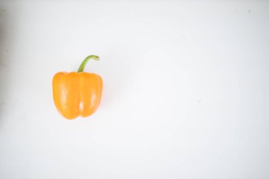 Beyaz bir masada izole edilmiş turuncu dolma biber.