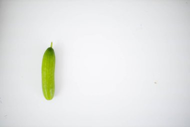 Beyaz bir masada duran taze salatalık.