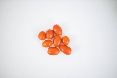 Beyaz bir masada izole edilmiş sekiz kiraz domatesi.