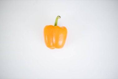 Beyaz bir masada izole edilmiş turuncu dolma biber.