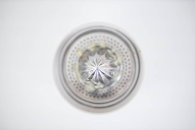 Çelik narenciye sıkacağı beyaz bir masada izole edilmiş.