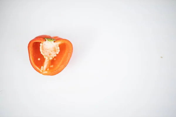 Meio pimentão vermelho isolado em uma mesa branca — Fotografia de Stock