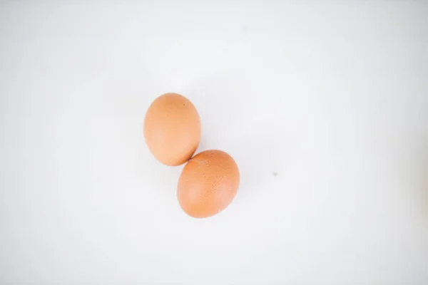 Två ägg isolerade på ett vitt bord ovanifrån — Stockfoto