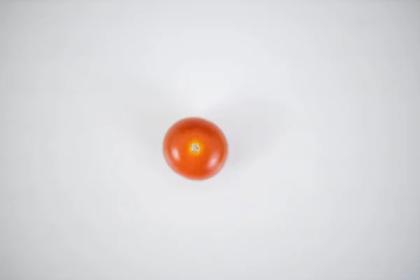 Un tomate cereza aislado en una mesa blanca — Foto de Stock