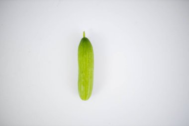 Beyaz bir masada duran taze salatalık.