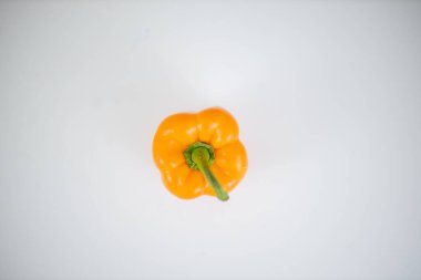 Beyaz bir masada izole edilmiş turuncu dolma biber.