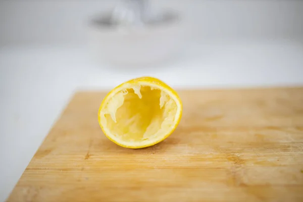 白い背景のまな板にレモンの皮を空にする — ストック写真