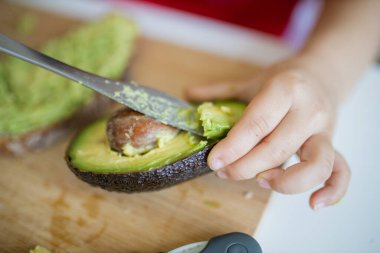 Avokadoyu kesen genç kadın elleri