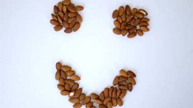 Beyaz bir masada gülen surat şeklinde küçük bir badem yığını.