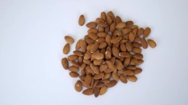 Beyaz masada izole edilmiş küçük bir yığın badem.