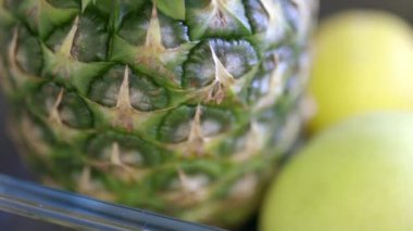 Elma, limon, limon ve bir kapta ananas.
