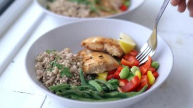 Karabuğday ve somon yemeğinden biber dilimi toplayan çatal.