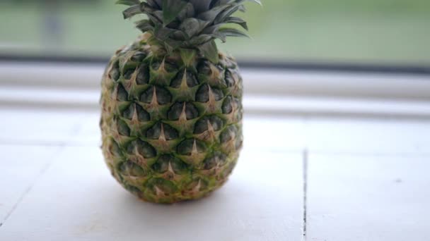 新鲜的菠萝放在厨房的白色小台子上 — 图库视频影像