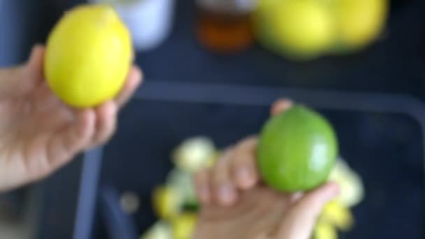 레몬 과 라임을 과일 조각 위에 들고 있는 여자 손 — 비디오