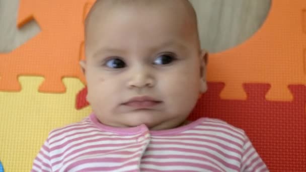 Bayi manis berbaring di tikar busa berwarna-warni — Stok Video