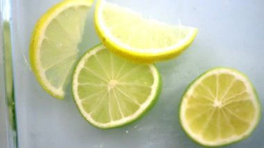 Kadın eli cam bir kabın içine limon koyuyor.