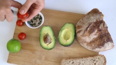 Domatesin yarısını dilimlenmiş ekmek ve avokadolarla kestim.