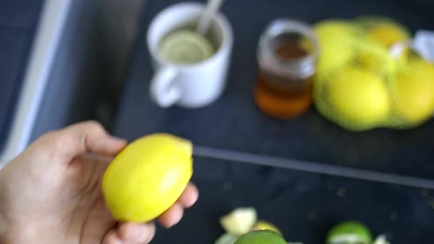 Tangan wanita memegang lemon dan jeruk di atas irisan buah — Stok Video